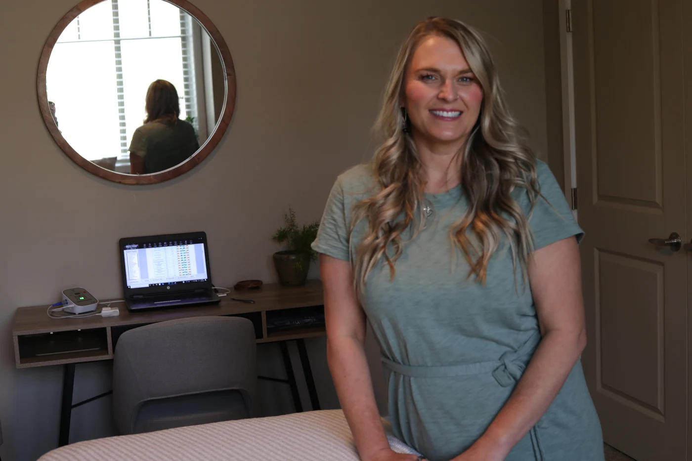 Trisha beside the biofeedback scan equipment at her Kamloops studio