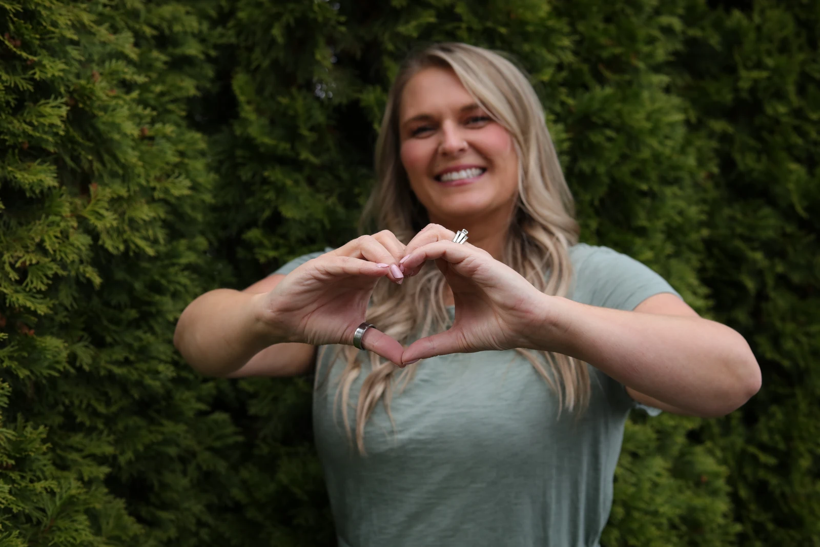 Trisha smiling and making a heart with her hands